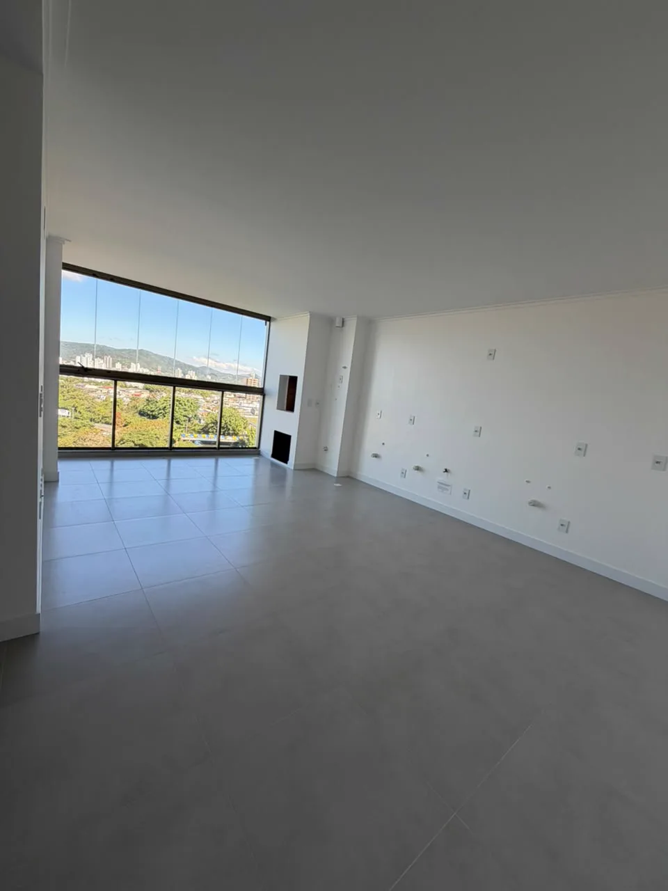 Sala de estar de apartamento em Itajaí com vista e lareira